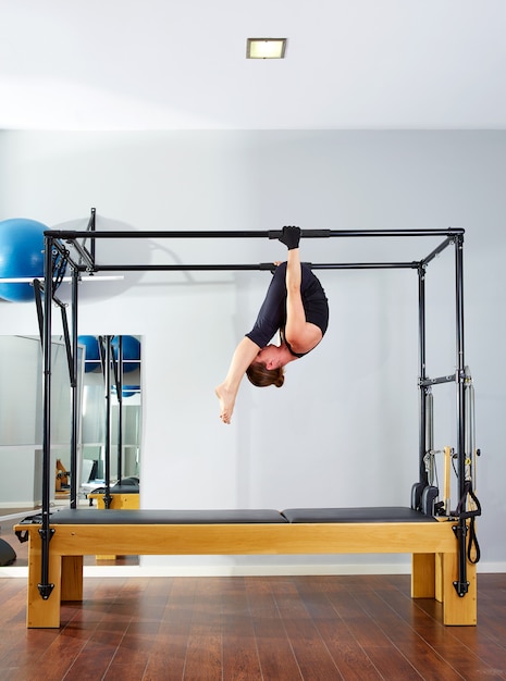 Donna di Pilates in cadillac acrobatico sottosopra