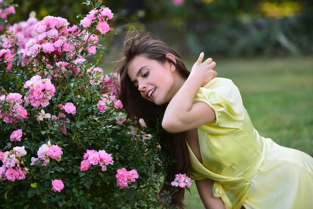 Donna di primavera nel giardino di rose all'aperto. La bellezza naturale gode della ricreazione estiva.