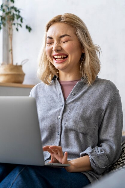 Donna di smiley che ride durante l'utilizzo di laptop
