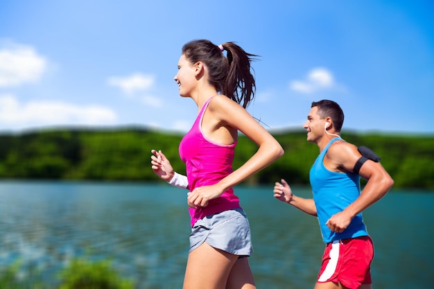 donna di sport di stile di vita sano che funziona sul mare di alba della passerella in legno