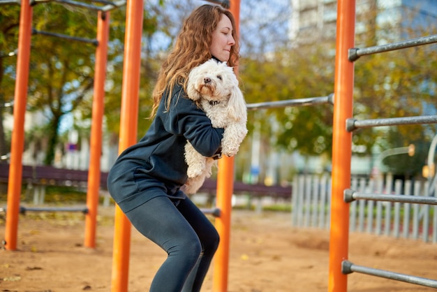 Donna di sport facendo esercizi con il cane all'aperto