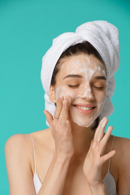 Donna di trattamento di bellezza che applica schiuma per la pulizia del viso