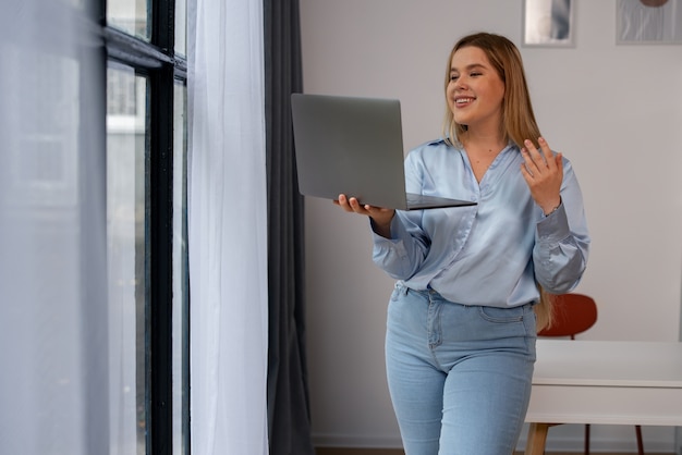 Donna di vista frontale che effettua videochiamate con il computer portatile