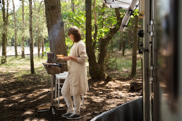 Donna di vista laterale che cucina in natura