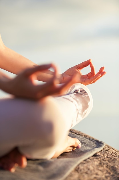 Donna di yoga che medita all'aperto, mani ravvicinate