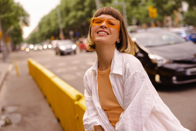 Donna divertente allo sguardo della città alla macchina fotografica