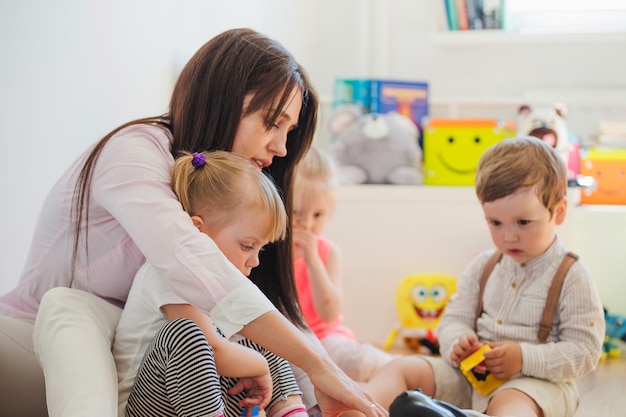 Donna e bambini seduti sul pavimento