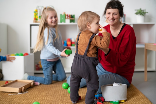 Donna e bambini sorridenti del colpo pieno all'interno