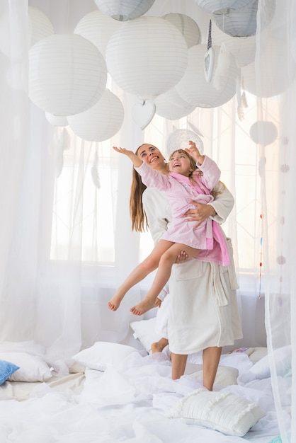 Donna e bambini sul letto.