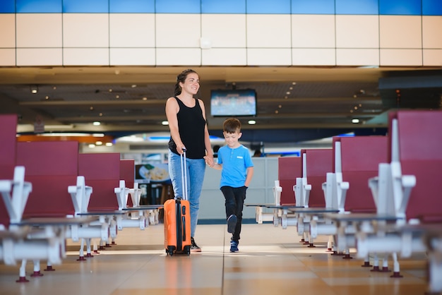 Donna e bambino che passano per il terminal dell'aeroporto airport