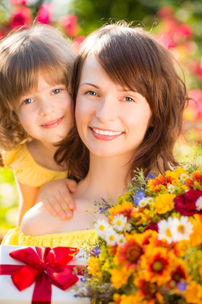 Donna e bambino con bouquet di fiori su sfondo verde Concetto di vacanza in famiglia primaverile Festa della mamma