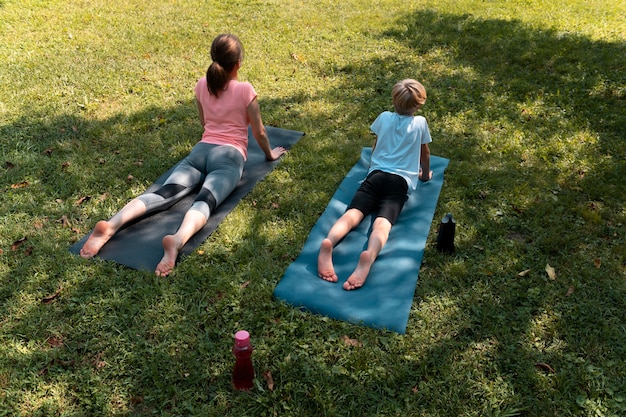 Donna e bambino su stuoie da yoga inquadratura completa