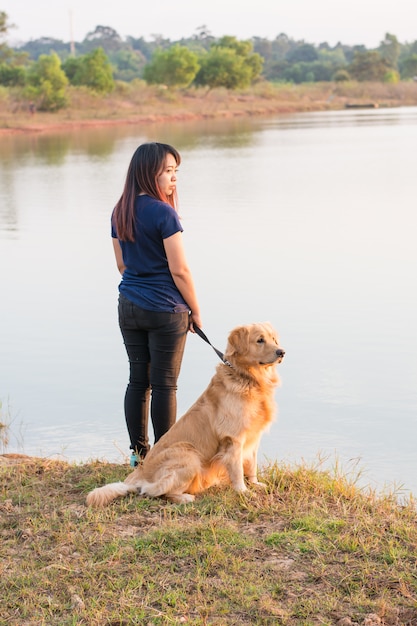 Donna e cane dorato sulla riva del fiume