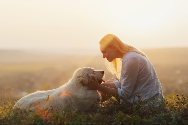donna e cane golden retriever sulla collina sull'erba verde