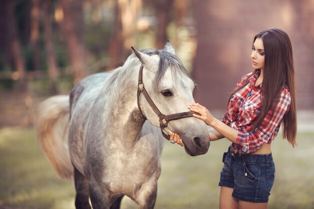 Donna e cavallo a scuola di equitazione