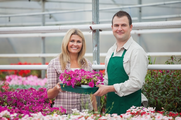 Donna e fiorista in possesso di una scatola di fiori