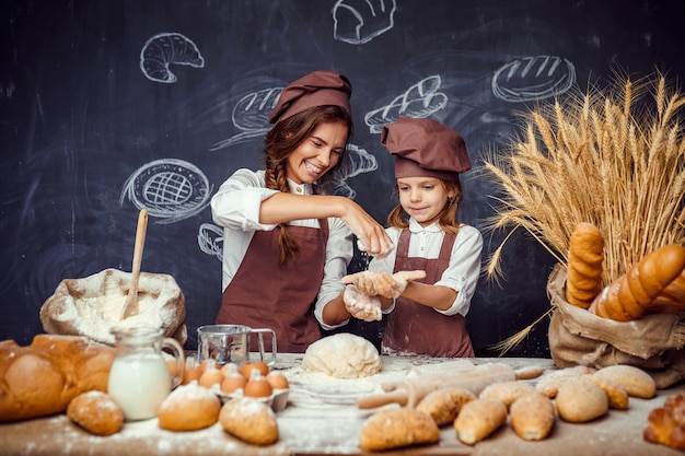 Donna e ragazza che producono insieme le pasticcerie