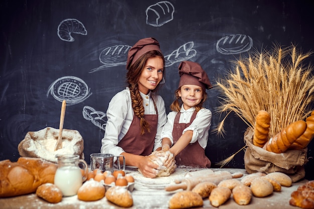 Donna e ragazza che producono insieme le pasticcerie