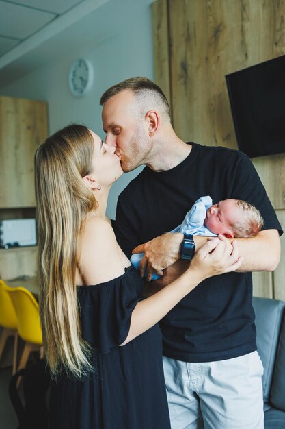 Donna e uomo che tengono un neonato Mamma, papà e bambino Closeup Ritratto di una giovane famiglia sorridente con un neonato in mano Famiglia felice sullo sfondo