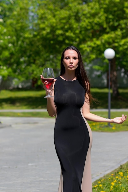 Donna elegante con vino nel parco