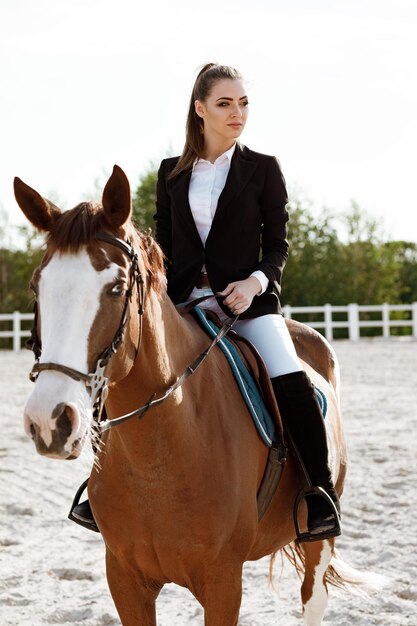 Donna elegante del cavaliere che monta il suo cavallo fuori