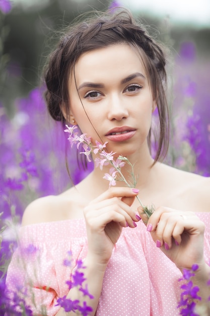 Donna elegante sexy sul prato di fiori. Bella femmina all'aperto. Concetto di libertà