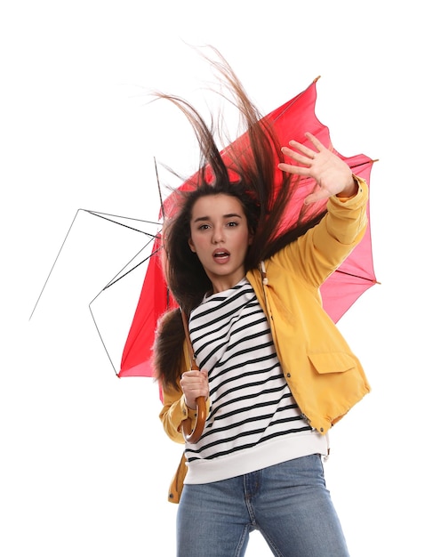 Donna emotiva con ombrello catturato da una raffica di vento su sfondo bianco