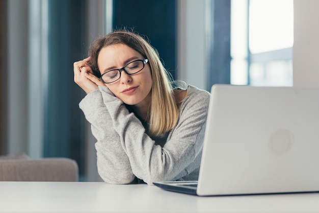 donna esausta al lavoro sbadiglia per sensazioni dolorose causate da una postura sbagliata