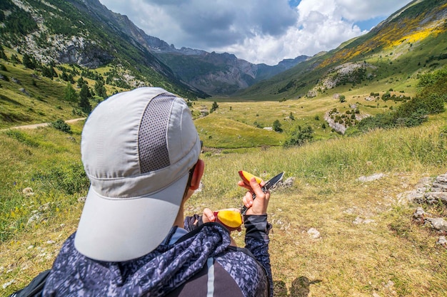 Donna escursionista che mangia frutta davanti al parco nazionale di Ordesa e Monte Perdido della valle dell'Otal