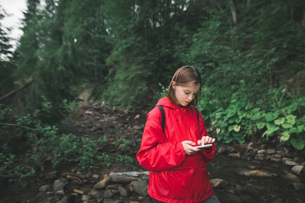 Donna escursionista guardando la mappa e la navigazione sullo smartphone