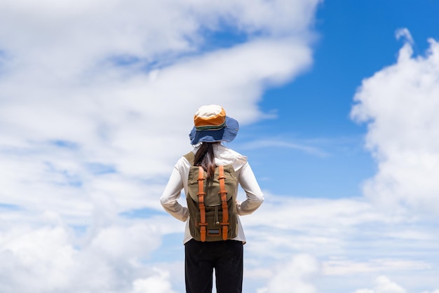 Donna escursionista in piedi e sopra il cielo blu