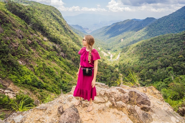 Donna escursionista su una roccia Vista della valle dalla scogliera Vietnam Da Lat