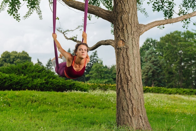 Donna esperta di yoga professionale con corpo muscolare che mostra asana yoga di mosca