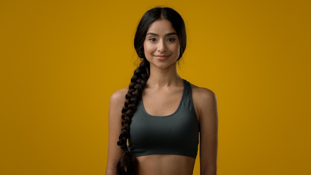 Donna etnica degli anni '20 Sport indiano sorridente forte ragazza snella in posa in studio giallo atleta alla ricerca