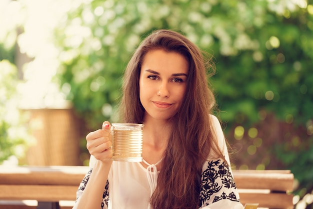 Donna felice al caffè all&#39;aperto