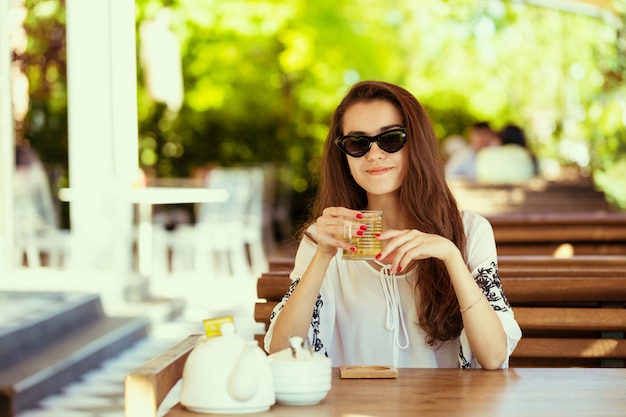 Donna felice al caffè all&#39;aperto