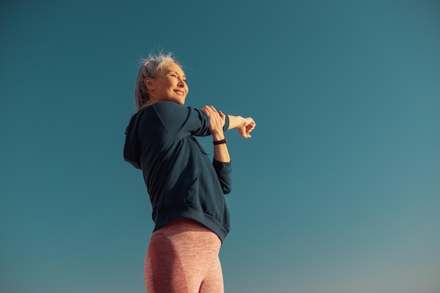 Donna felice attiva che si esercita in una calda giornata sulla costa