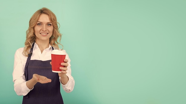 Donna felice barista in grembiule da cuoco bere caffè da asporto copia spazio pubblicità