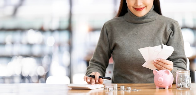 Donna felice che calcola usando la macchina per gestire le finanze domestiche a casa una giovane donna concentrata fa calcoli sulla calcolatrice pagando le bollette, le tasse o le spese