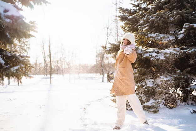 Donna felice che cammina nella giornata invernale innevata all'aperto Concetto di viaggio di riposo per le vacanze di moda invernale