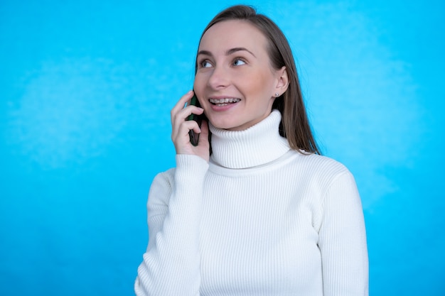 Donna felice che comunica tramite smartphone e distogliere lo sguardo