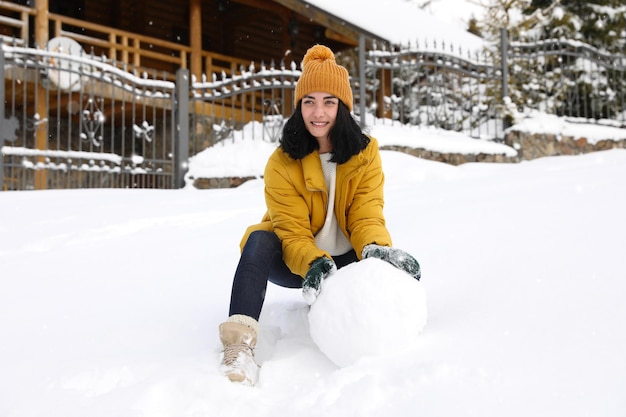 Donna felice che fa palla per pupazzo di neve all'aperto Vacanze invernali