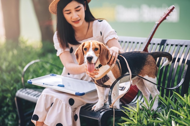 Donna felice che gioca con il suo cane beagle nel parco all'apertoAttività ricreative di stile di vita