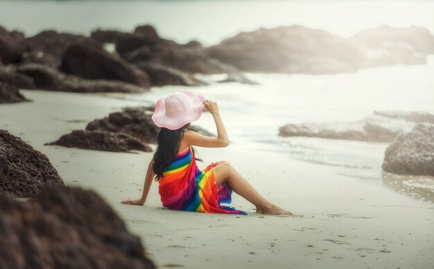 Donna felice che gode della spiaggia che si distende allegra in estate dal mare tropicale