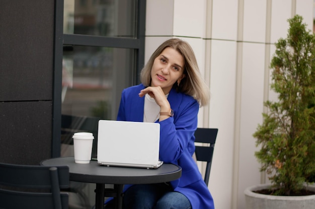 Donna felice che guarda contenuti multimediali online sul laptop seduto in un parco