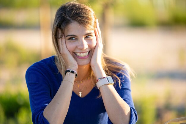 Donna felice che guarda lontano e sorride mentre si diverte all'aperto nella natura di giorno