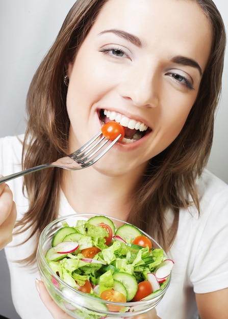 Donna felice che mangia insalata