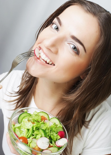 Donna felice che mangia insalata