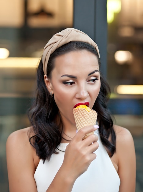 Donna felice che mangia un delizioso cono gelato in viaggio di vacanza.