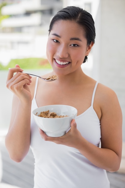 Donna felice che mangia una ciotola di cereali